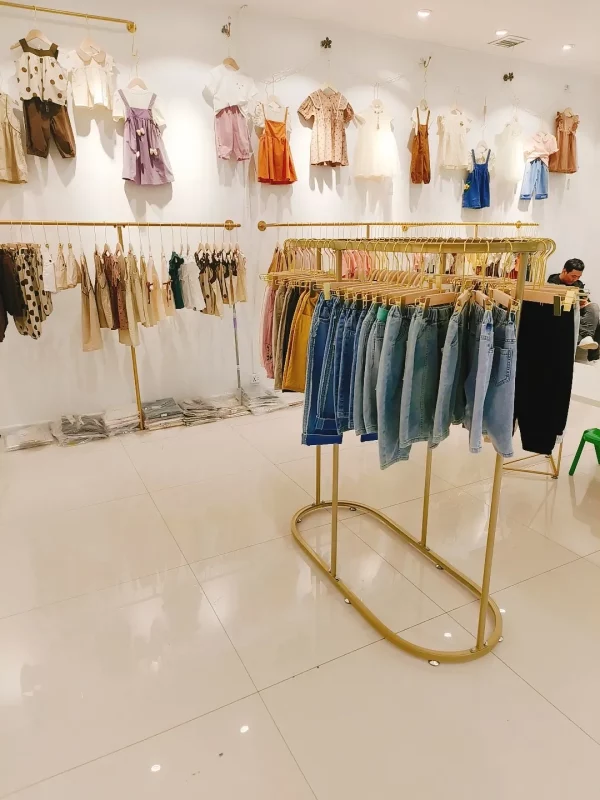 Portant vêtement doré rond style boutique